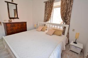 Un dormitorio con una cama blanca y una ventana. en Bell Tower Apartment, en Budva