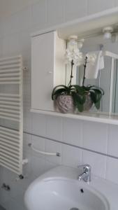 uma casa de banho com um lavatório e um vaso com flores em B&B LA CASA DEL CASALE em Roseto degli Abruzzi
