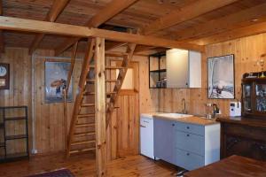 a kitchen with a ladder in a wooden cabin at Ogród Shinrin Yoku Odpoczynek w Lesie in Srokowo
