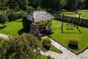 a garden with a gazebo and a swing at Vila Sraige in Palanga