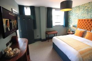 a hotel room with a bed and a desk and window at Westow House in Crystal Palace