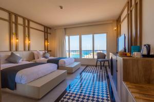 a hotel room with two beds and a television at The Boutique Hotel Hurghada Marina in Hurghada