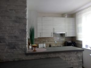 a kitchen with white cabinets and a brick wall at BOGUCHWALY in Boguchwały