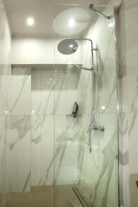 baño con ducha y puerta de cristal en AMMOESSA APARTMENTS, en Plataria