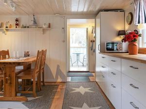 a small kitchen with a table and a kitchen with a refrigerator at Holiday home LYSEKIL XXIV in Lysekil