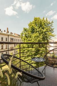 patio z 2 krzesłami i stołem na balkonie w obiekcie Angelus Apartments w Krakowie