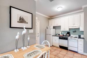 a kitchen with white cabinets and a table with flamingos on it at Dauphin Island Beach Club #201 in Dauphin Island