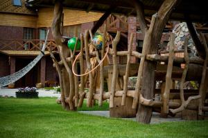 a wooden playground with a ball and a swing at Vila Sraige in Palanga