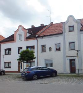 a blue car parked in front of a house at Gästeunterkunft Gangkofen in Gangkofen