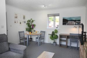 a living room with a table and chairs and a couch at ChiPad Mono - Comfy City Centre Apartment with Free Parking Space in Chichester