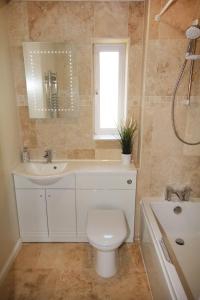 a bathroom with a toilet and a sink and a window at ChiPad Mono - Comfy City Centre Apartment with Free Parking Space in Chichester +15 photos