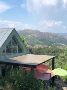 a house with a roof with a view of a mountain at Casa do Eido dos Calhões in Ponte de Lima