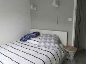 - une chambre dotée d'un lit avec des draps bleus et blancs dans l'établissement Les baigneurs, à Merville-Franceville-Plage