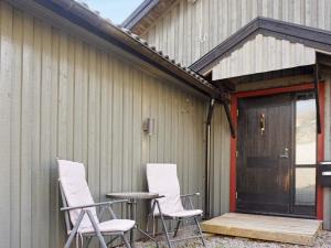 two chairs and a table in front of a building at 5 person holiday home in str mstad in Strömstad