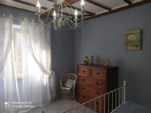 1 dormitorio con lámpara de araña, vestidor y ventana en Alloggio turistico Amalasunta, en San Lorenzo Nuovo
