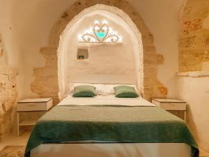 um quarto com uma cama grande e uma janela arqueada em Trullo Bianco Ostuni em Ostuni