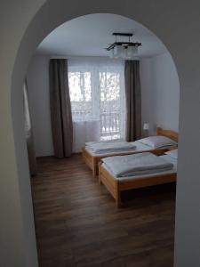 a bedroom with two beds and a window at Apartamenty Bogusia Korbielów Pilsko in Korbielów