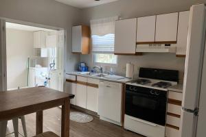 a kitchen with white appliances and a wooden table at Hyde Park Getaway - Close to Square & Downtown! in Cincinnati