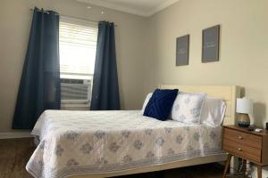 1 dormitorio con 1 cama con cortinas azules y ventana en Hyde Park Getaway - Close to Square & Downtown! en Cincinnati