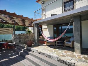 eine Hängematte auf der Terrasse eines Hauses in der Unterkunft Casa das Santiagas em Arouca in Arouca