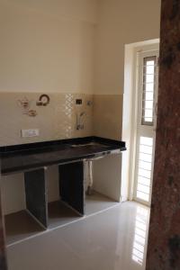 a kitchen with a black counter and a sink at Nature's Lap Homestay in Igatpuri