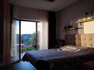 a bedroom with a bed with a view of a balcony at Apartment Deluxe Sunny Valley Milmari S8 in Kopaonik