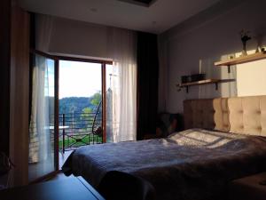 a bedroom with a bed with a view of a balcony at Apartment Deluxe Sunny Valley Milmari S8 in Kopaonik +41 photos