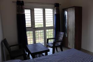 a room with a table and chairs and a window at Nature's Lap Homestay in Igatpuri