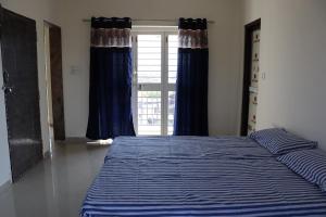 a bedroom with a blue bed with a window at Nature's Lap Homestay in Igatpuri