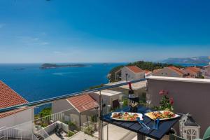 two pizzas on a table on a balcony with the ocean at Deluxe Cosmopolit apartment in Cavtat