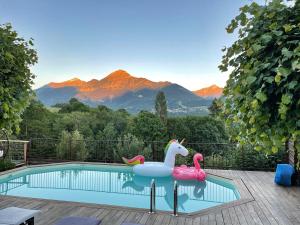 a swimming pool with two inflatable swans and avisorvisorvisor at Chambre d'Hôtes La Grange des Ecrins in Chabottes