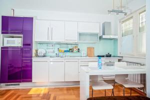 a kitchen with white cabinets and purple appliances at LuxApart Bascarsija Old City Centar free parking in Sarajevo