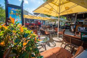 an outdoor cafe with tables and chairs and umbrellas at Beach Hostel Balatonboglár in Balatonboglár