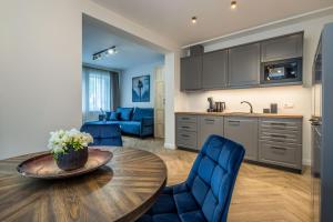 a kitchen and living room with a table and chairs at Smėlynas Boutique & SPA in Palanga