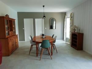 een eetkamer met een houten tafel en stoelen bij La Maison de Joindy in Saint-Cyprien