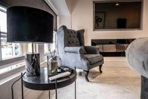 un salon avec une chaise et une table avec une lampe dans l'établissement Luxury royal mile boutique 2bedroom apartment, à Édimbourg