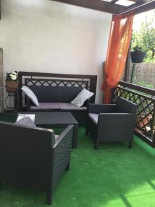 um pátio com cadeiras e um sofá na varanda em Domek Kasi em Ustka