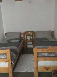 a bedroom with two twin beds and a chair at Domek Kasi in Ustka