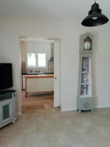 een woonkamer met een klok op een plank bij La Maison de Joindy in Saint-Cyprien