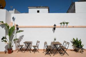 a patio area with chairs, tables, chairs and umbrellas at Planeta Cadiz Hostel in Cádiz