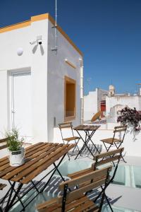a patio area with chairs, tables and umbrellas at Planeta Cadiz Hostel in Cádiz