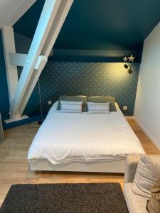 a bedroom with a white bed with a blue wall at Le Seven in Bordeaux