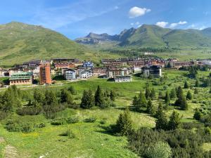 a small town on a hill with mountains in the background at Be Smiling Appartament in Passo del Tonale