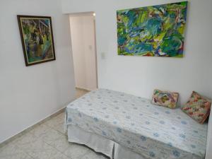 1 dormitorio con 1 cama y una pintura en la pared en Apartments Almirante Goncalves, en Río de Janeiro
