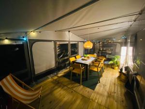 uma sala de jantar com uma mesa e cadeiras numa tenda em Przyczepa FOREMKI w Molo Surf em Jastarnia