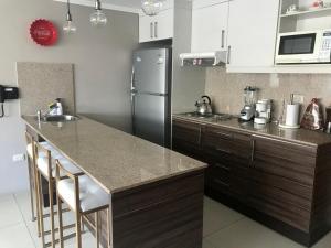 cocina con nevera y encimera en Apartamento completo Edificio Riverfront 1 Puerto Santa Ana, en Guayaquil