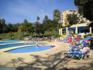grupa ludzi siedząca wokół basenu w obiekcie Minerva Apartments Sea View w mieście Benalmádena