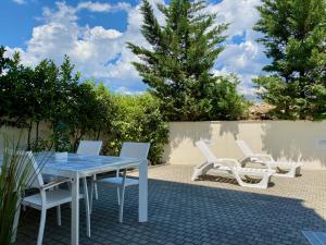 a patio with a table and chairs and trees at Private pool and Mediterranean garden apt Mia in Šilo