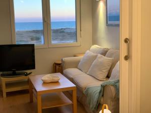 sala de estar con sofá y TV en Apartamento Canaleta Aitana frente al mar en Punta Umbría