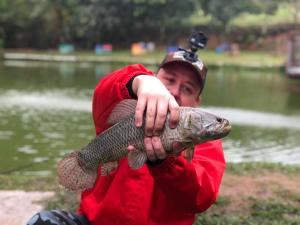 a man holding a fish in his hands at Pesque pague pousada do Carlinho in Pinheiral